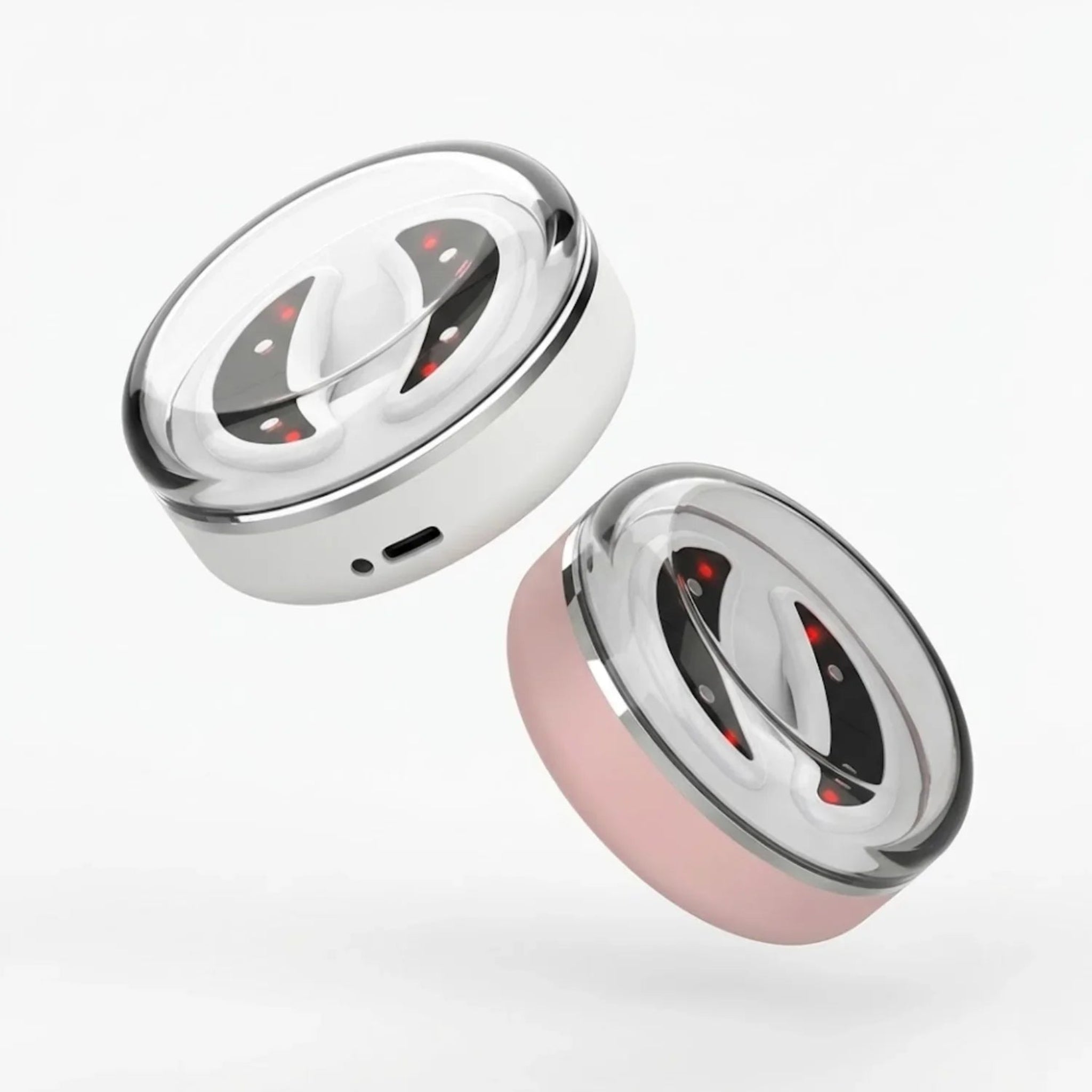 Two light therapy eye patches, one silver and one pink, on a white background