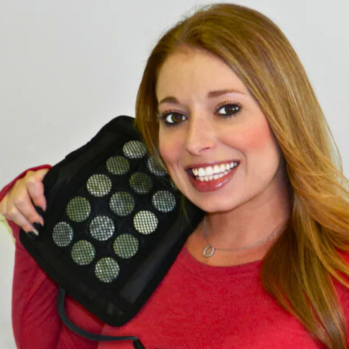 Woman holding the Healing Pad Mini Infrared Heating Pad, showcasing its innovative design and features.