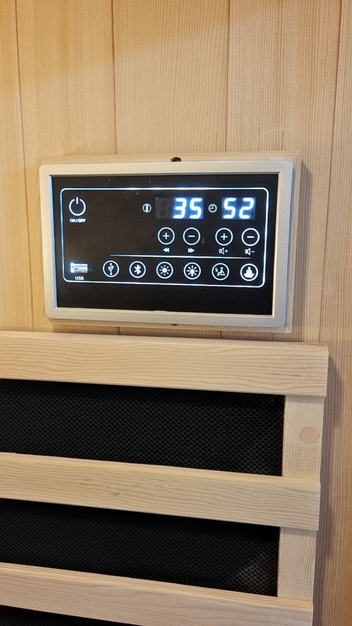 Control panel with digital display on a wooden wall inside a Nicebeam Canadian Hemlock sauna