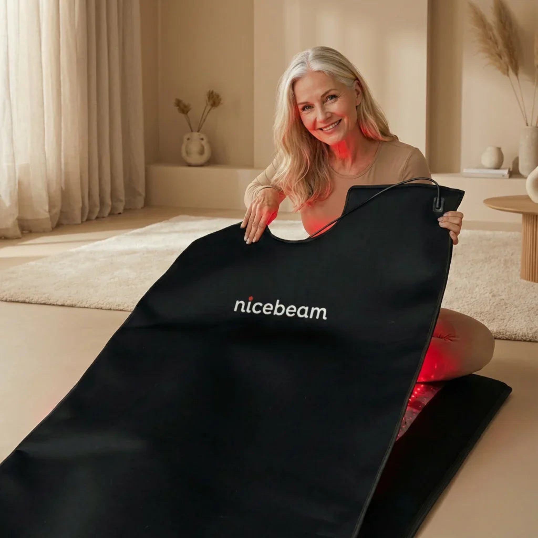 Woman holding a black mattherapy bag with 'nicebeam' logo in a room with neutral decor.
