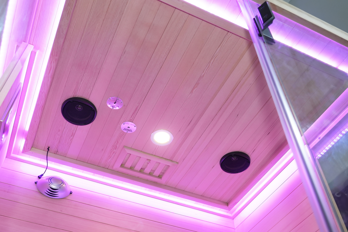 Interior view of a full spectrum infrared sauna featuring ceiling lights and speakers with a sleek design.