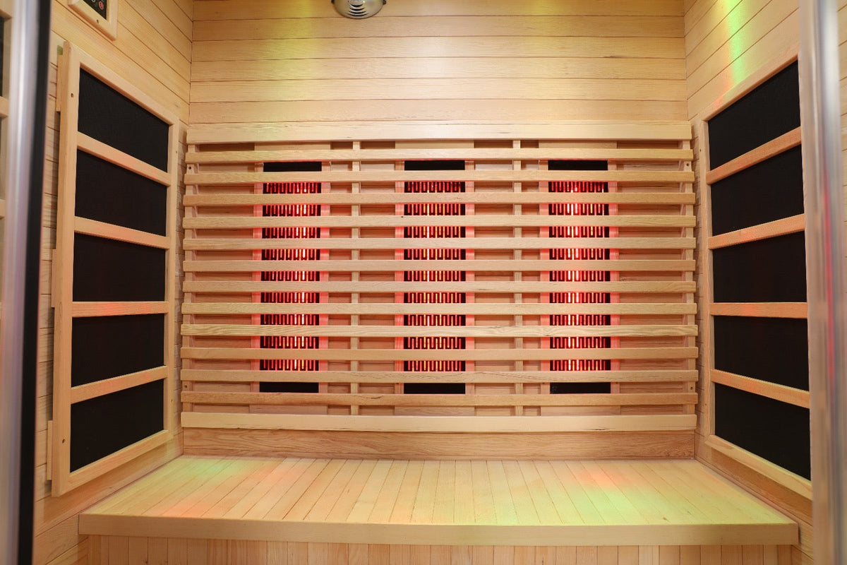 Interior of the Blisspod Venetian full spectrum infrared sauna with wooden benches and glowing infrared panels.