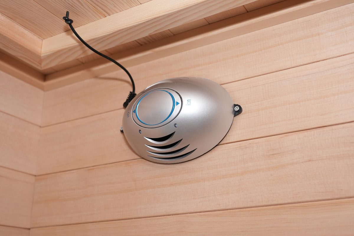 Full spectrum infrared sauna control panel in a wooden interior, showcasing sleek design and functionality.