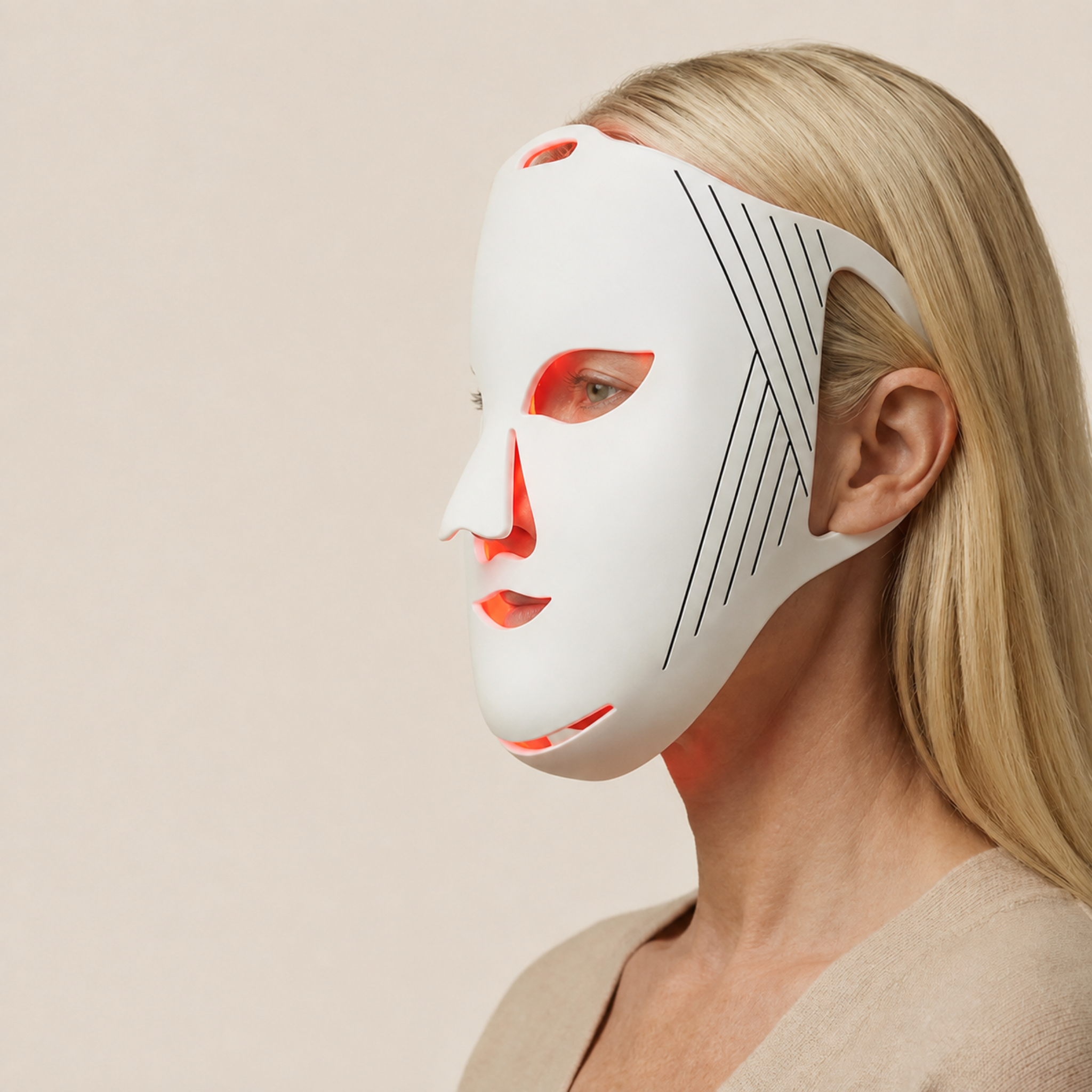 A blonde woman shown in profile wearing a white Nicebeam LED light therapy face mask with black geometric line details on the cheek, set against a solid beige background.