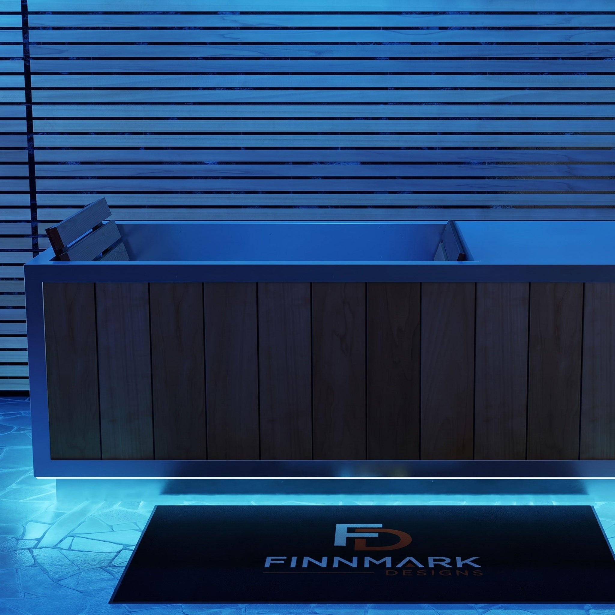 A modern FInnmark SoulCold plunge tub, shown in a blue-lit setting with a black FINMARK DESIGNS mat on the ground.