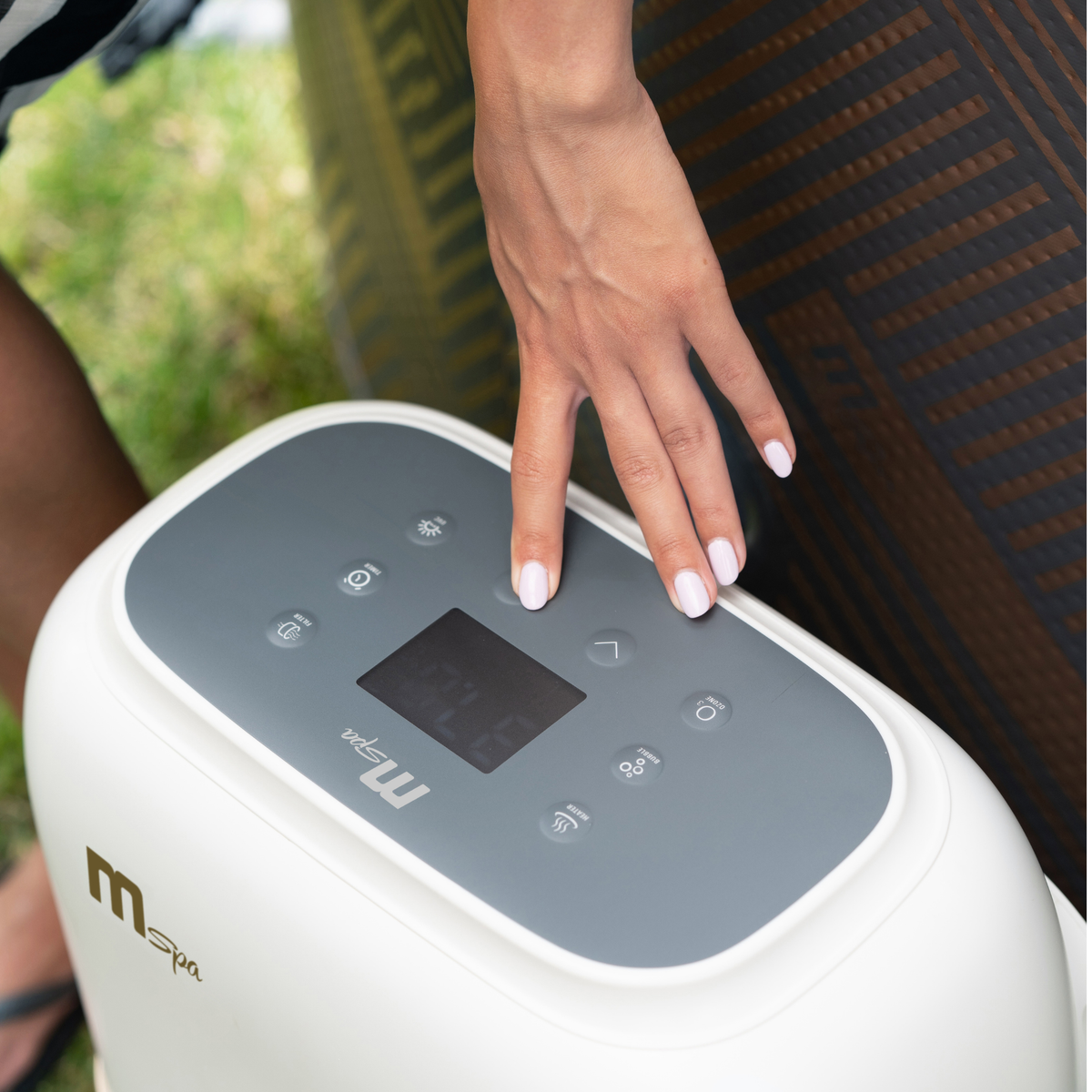 User interacting with the control panel of the MSPA Verto Series rigid hot tub.