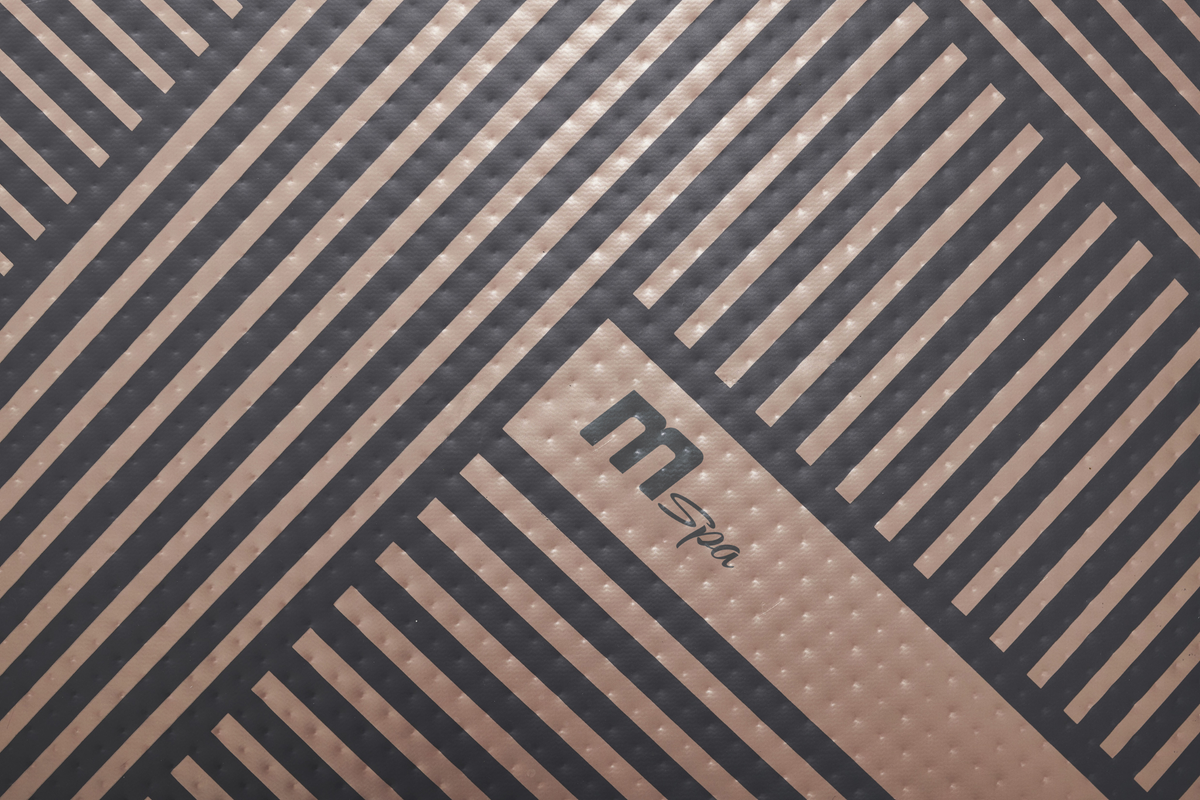 Close-up of the mSpa logo and textured surface of a rigid hot tub from the Verto Series.