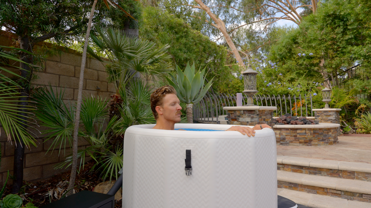 Person using a RevX Inflatable Barrel in a backyard