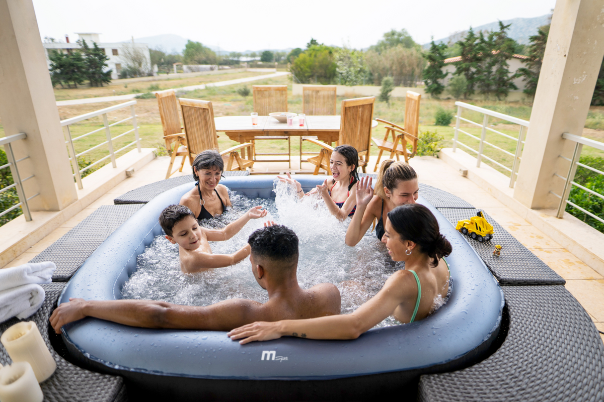Group of people enjoying a hot tub on a deck with a scenic view