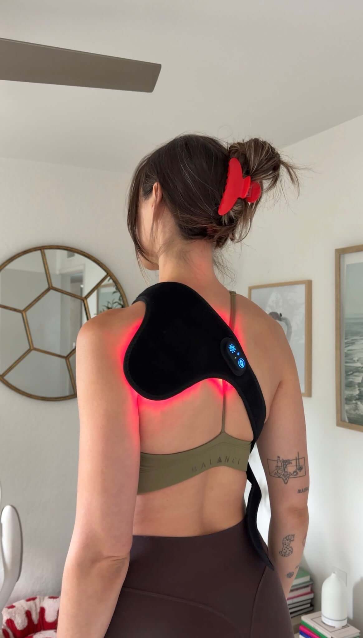 Person wearing the wrap over hershoulder with red lights in a room.