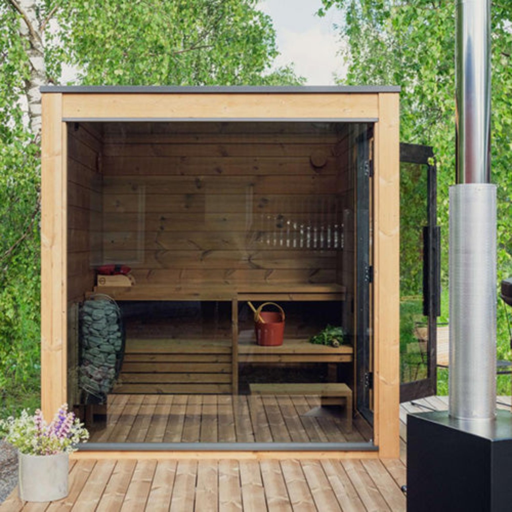 ThermaSol Nordic Dawn outdoor sauna with interior view, surrounded by greenery