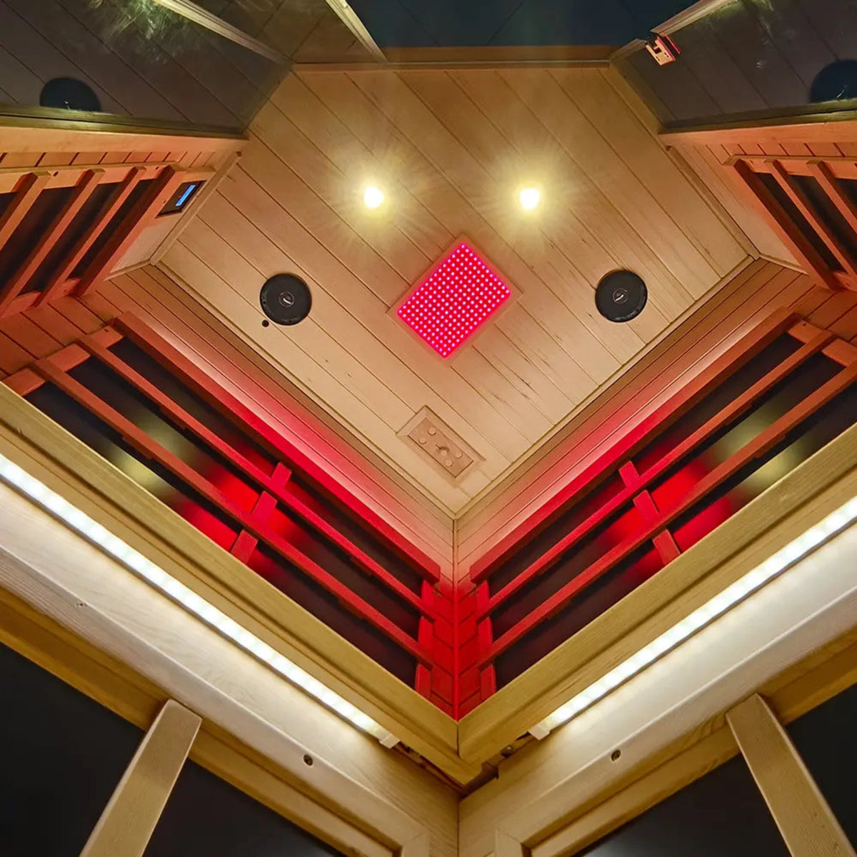 Interior view of a corner infrared sauna for 2-3 people featuring red lighting and sound system.