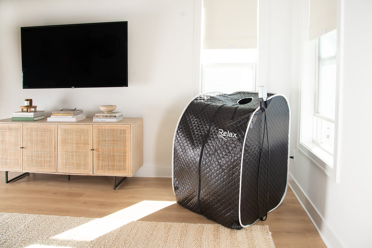 Black Pro Sauna, a portable sauna, placed in a modern living room setting
