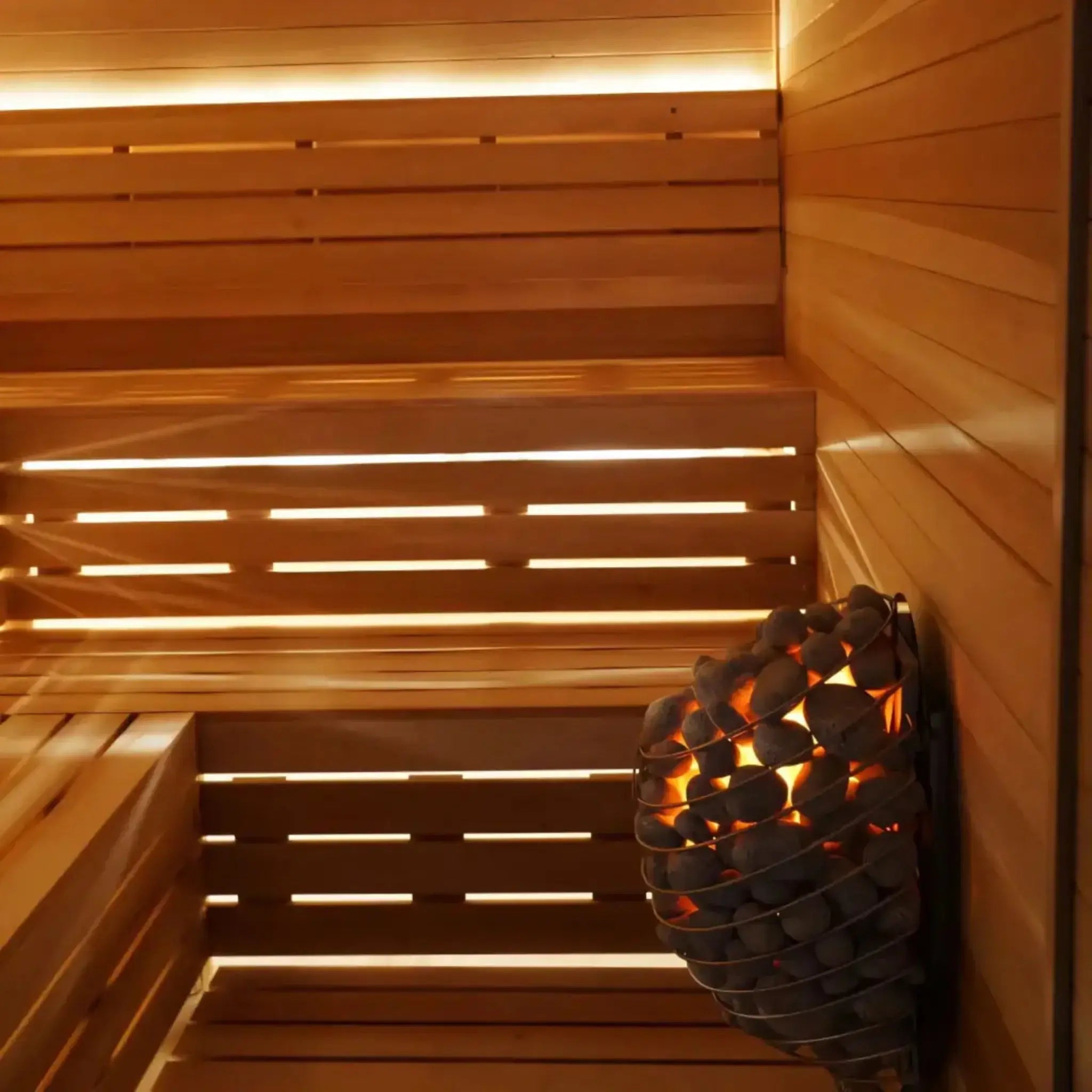 Wooden sauna interior with a basket of hot stones.