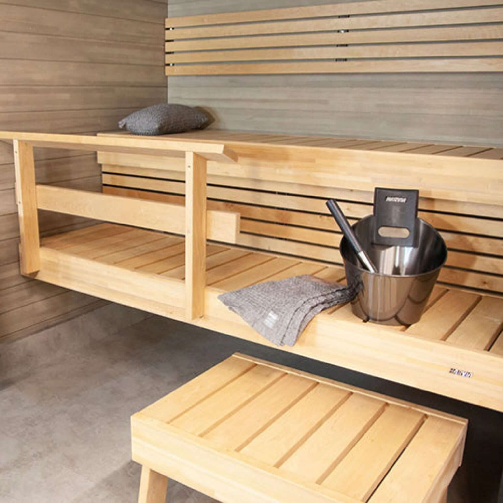 Harvia sauna accessory set —lifestyle interior sauna view with accessory kit on bench