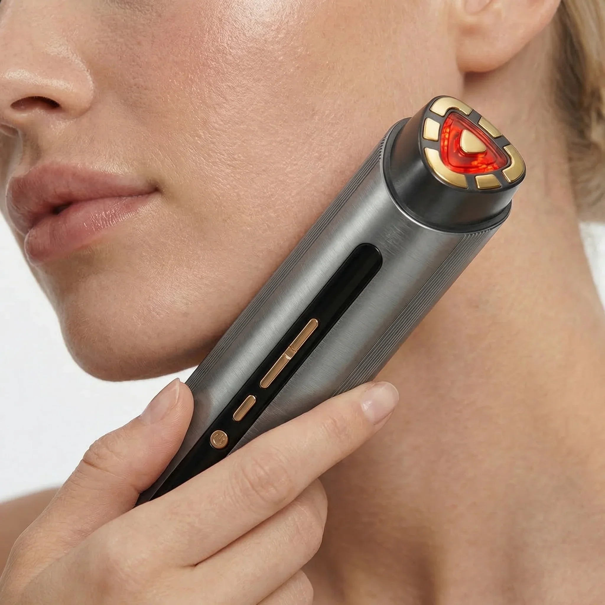 Person using a Nicebeam facial device with a red light on a white background. showing close up view
