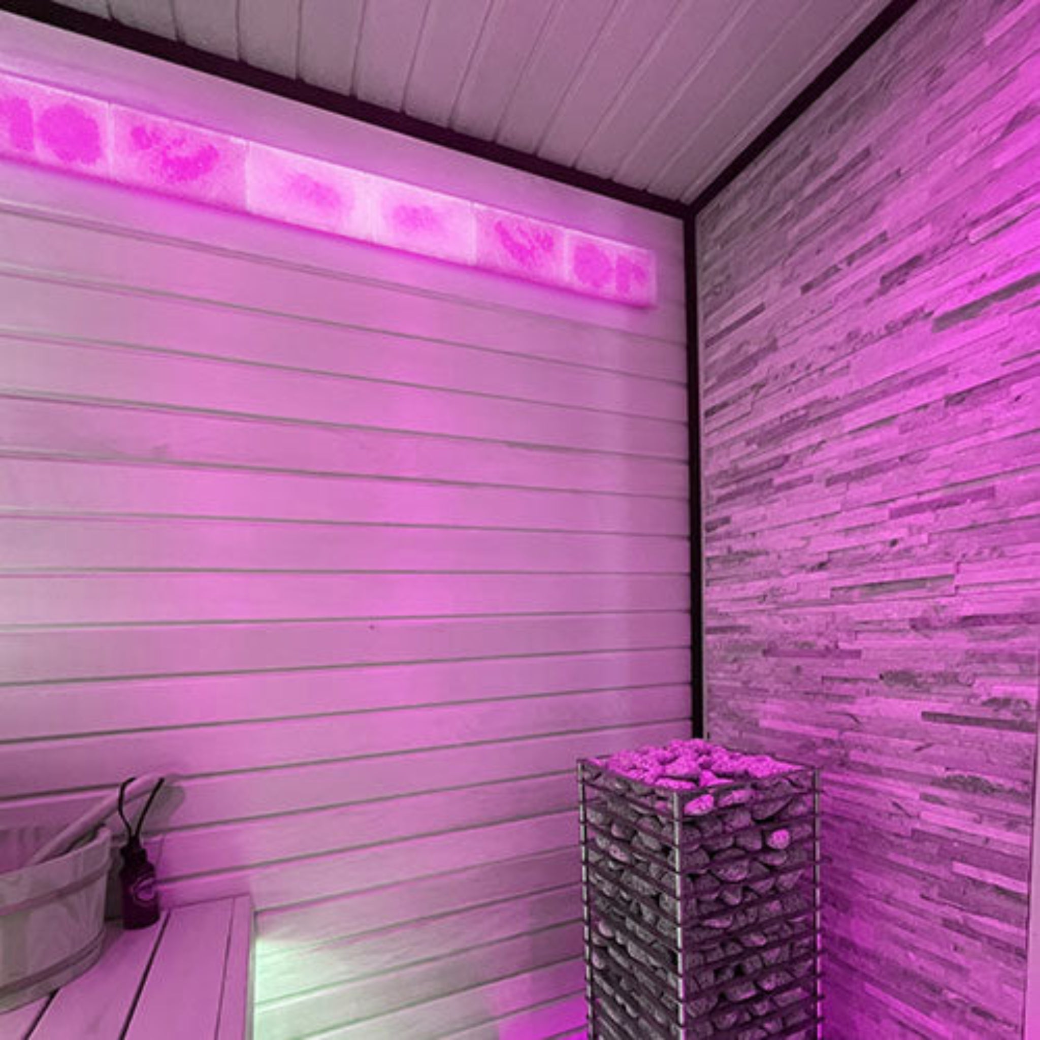 Pink LED strip light on a wooden wall with a stone structure in a room with PROSAUNAS Small Himalayan Salt Light Feature