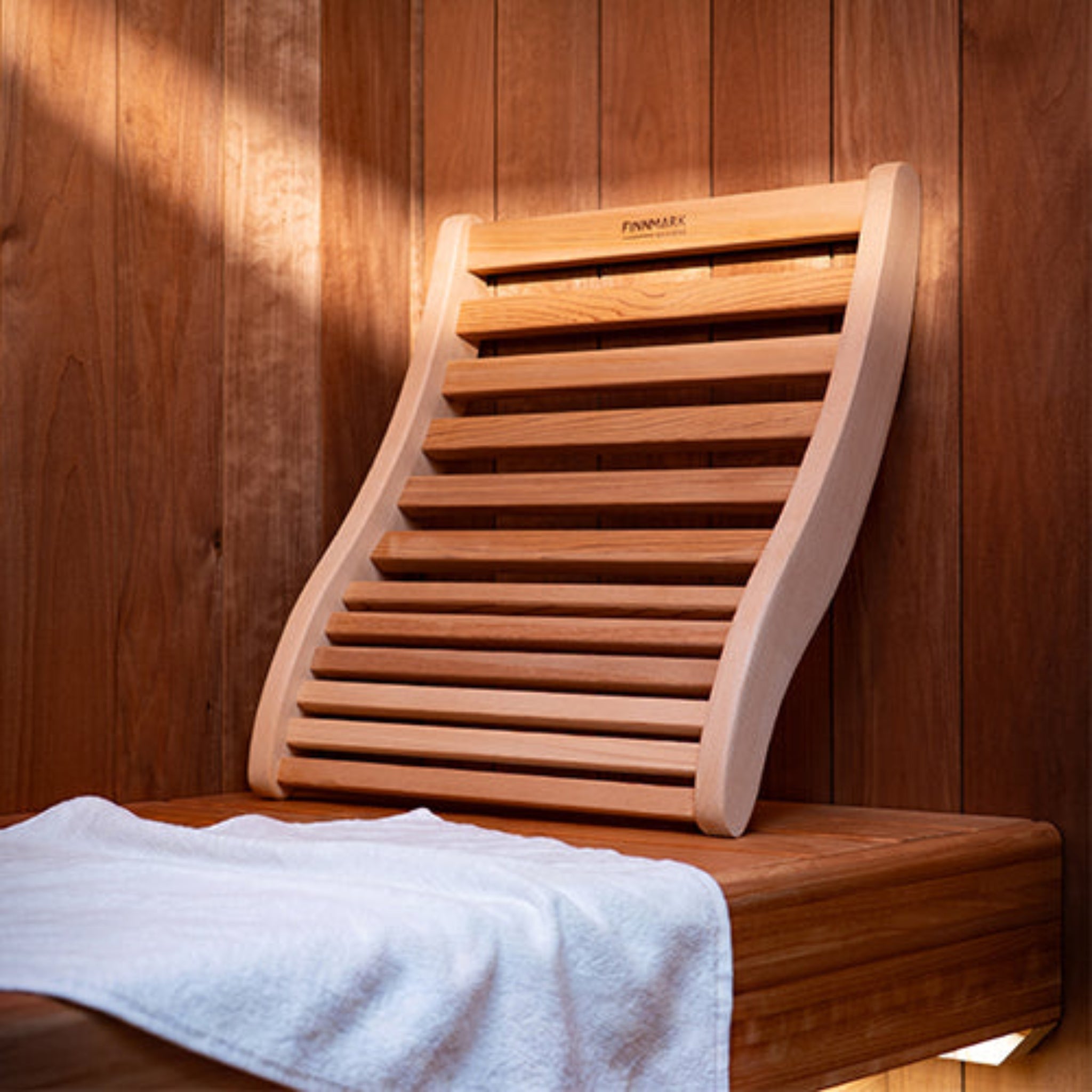 FInnmark Ergonomic S-Shape Sauna Backrest in a wooden sauna next to a white towel