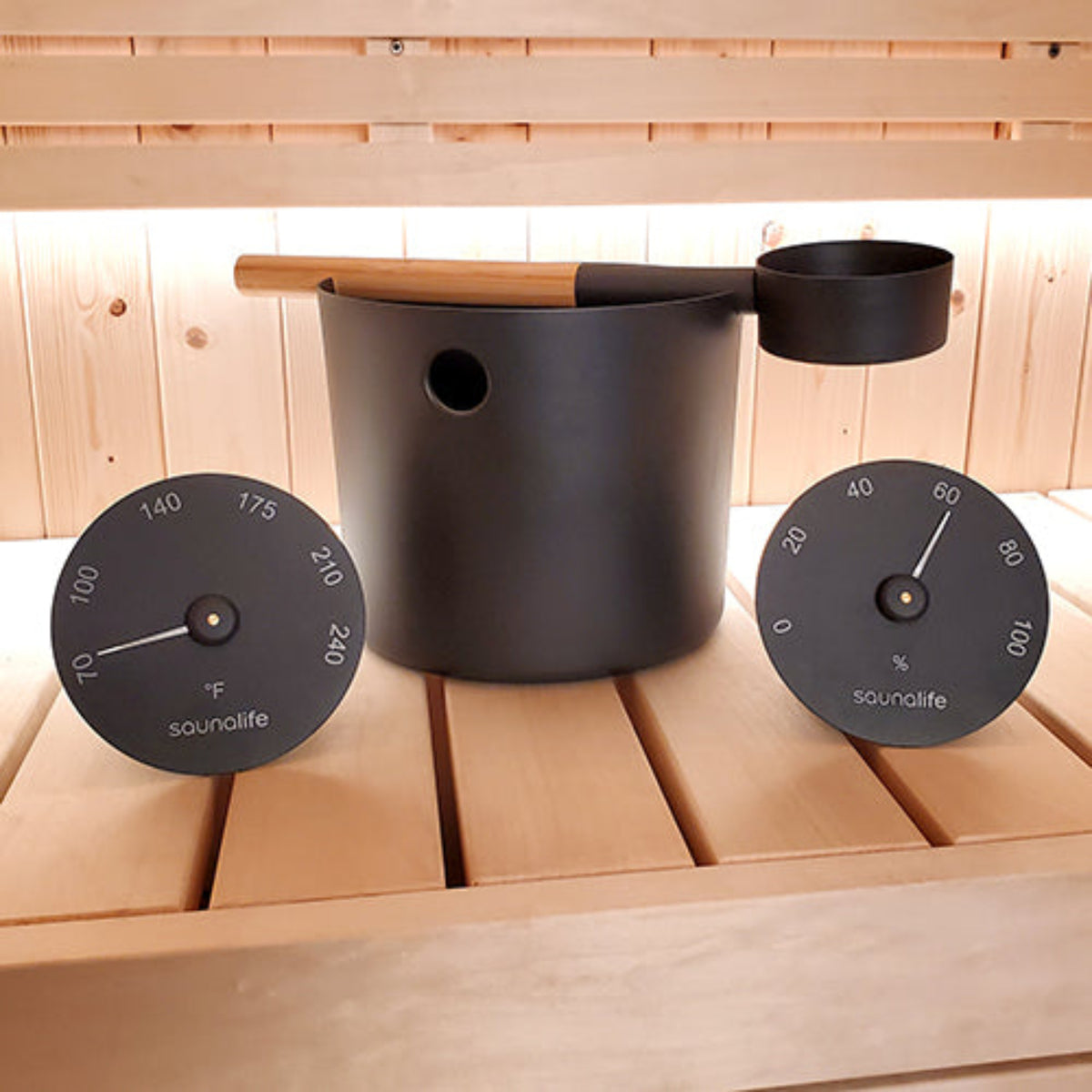 SaunaLife Essentials Set 5 Aluminum Sauna Bucket and Ladle Set w/ Black Thermometer and Hygrometer on a sauna bench