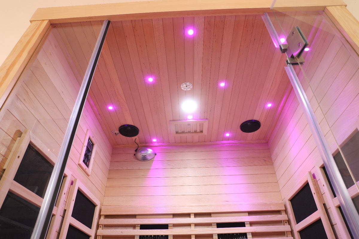 Interior view of Blisspod Full Spectrum Infrared Sauna showcasing purple lighting and sound features.