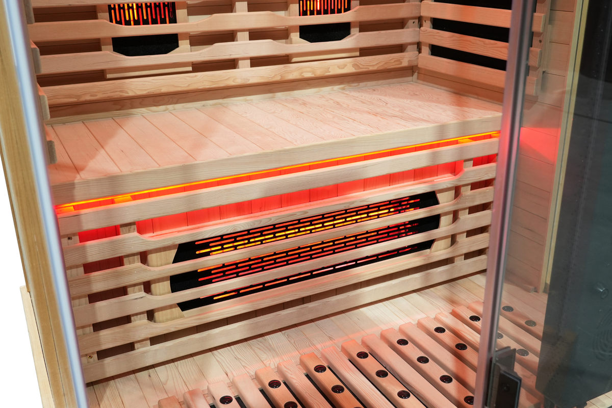 Interior view of a full spectrum infrared sauna with red light therapy features and wooden seating.