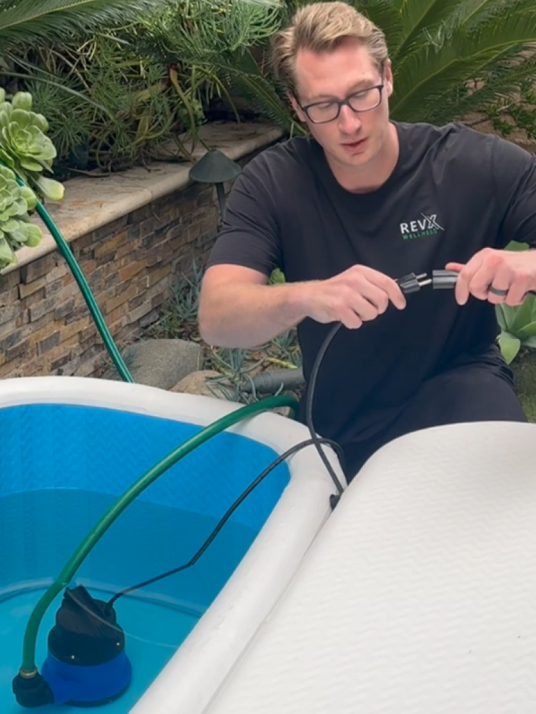 Person holding the discharge hose for a RevX drain pump