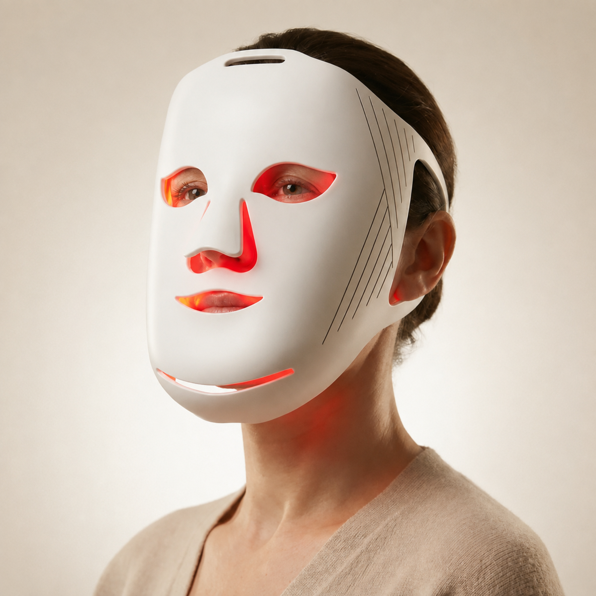 Woman wearing Nicebeam red LED light face mask on a beige background