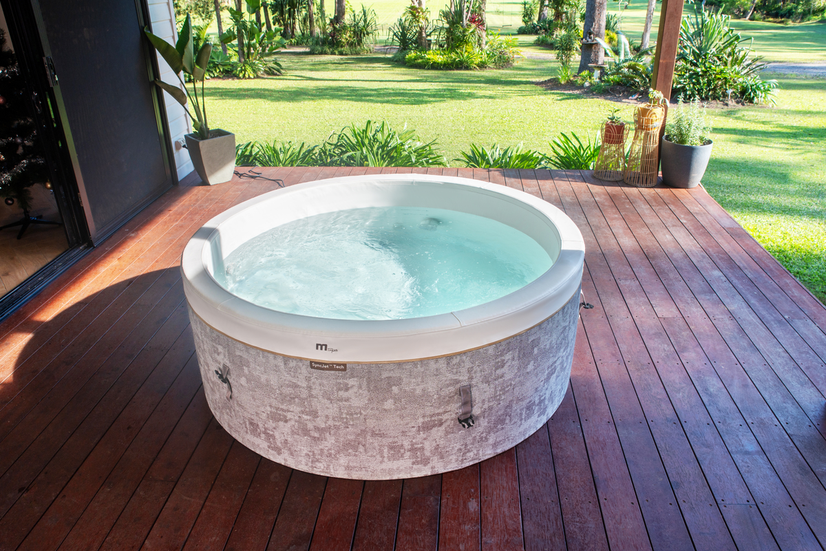 MSPA Cocoon rigid hot tub on a wooden deck surrounded by greenery, perfect for relaxation and outdoor enjoyment.