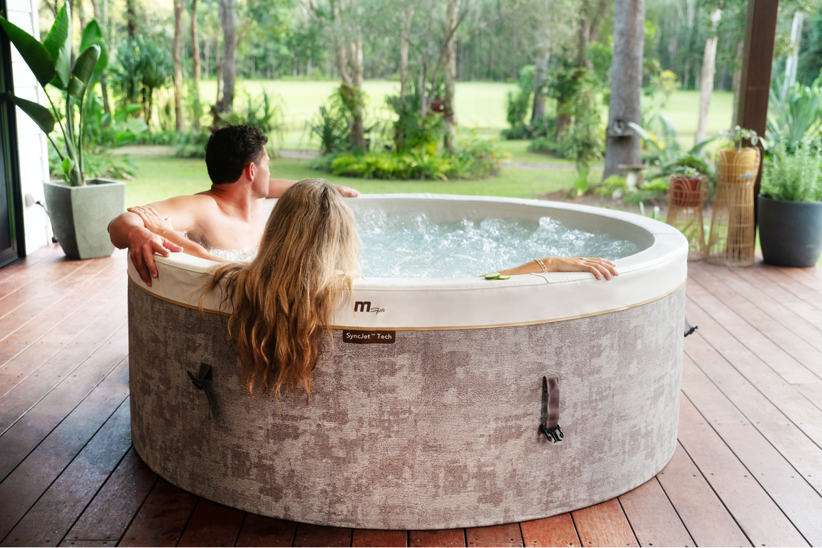 MSPA Cocoon rigid hot tub with two people enjoying the spa experience in a serene outdoor setting.