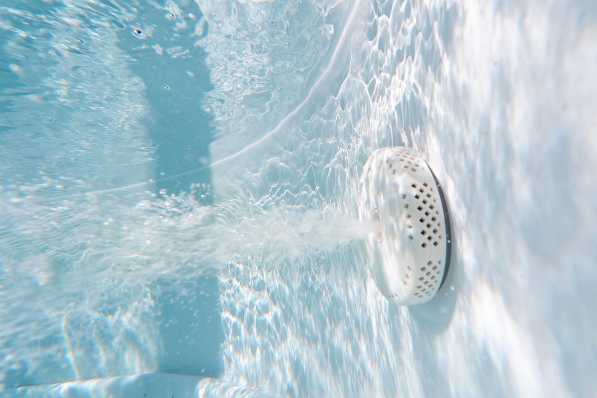 Underwater view of the water jet system in an MSPA Cocoon rigid hot tub, showcasing spa features and water flow.