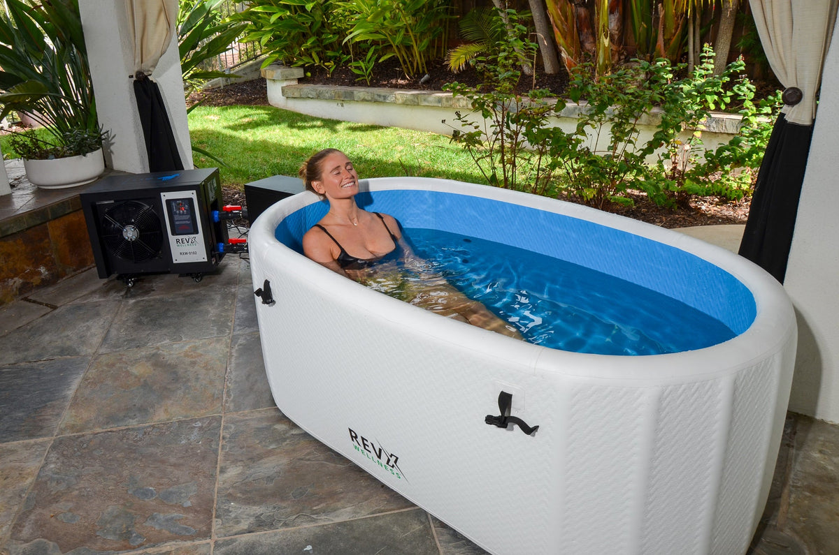 Person reclining in the RevX Inflatable Tub Deluxe outdoors