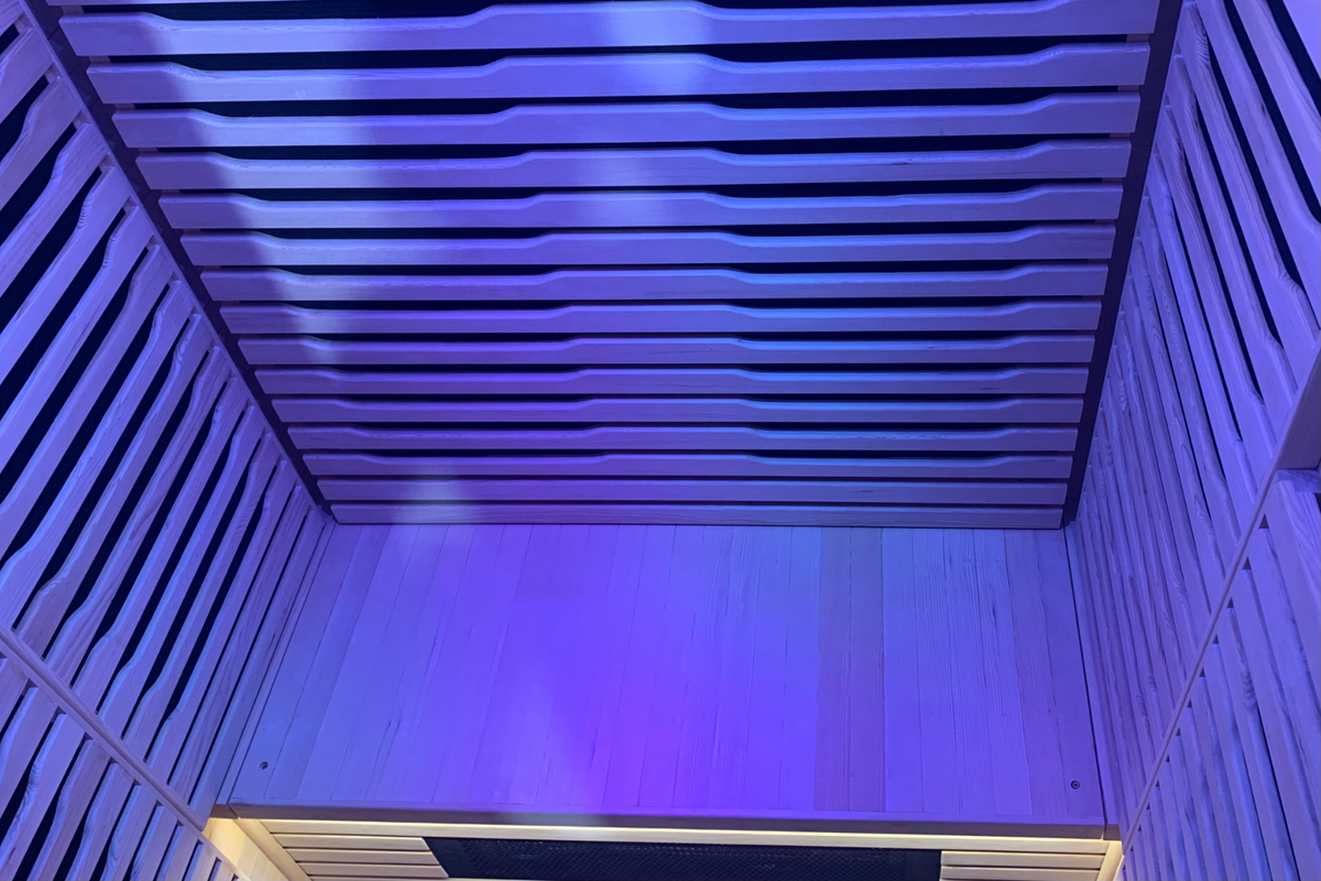 Interior view of a Full Spectrum Indoor Sauna with purple ambient lighting and wooden slats.