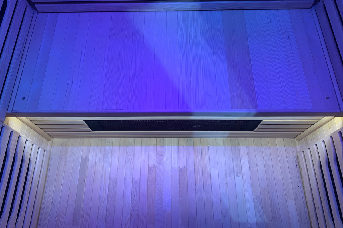 Interior view of a Full Spectrum Indoor Sauna with blue lights illuminating the wooden paneling.