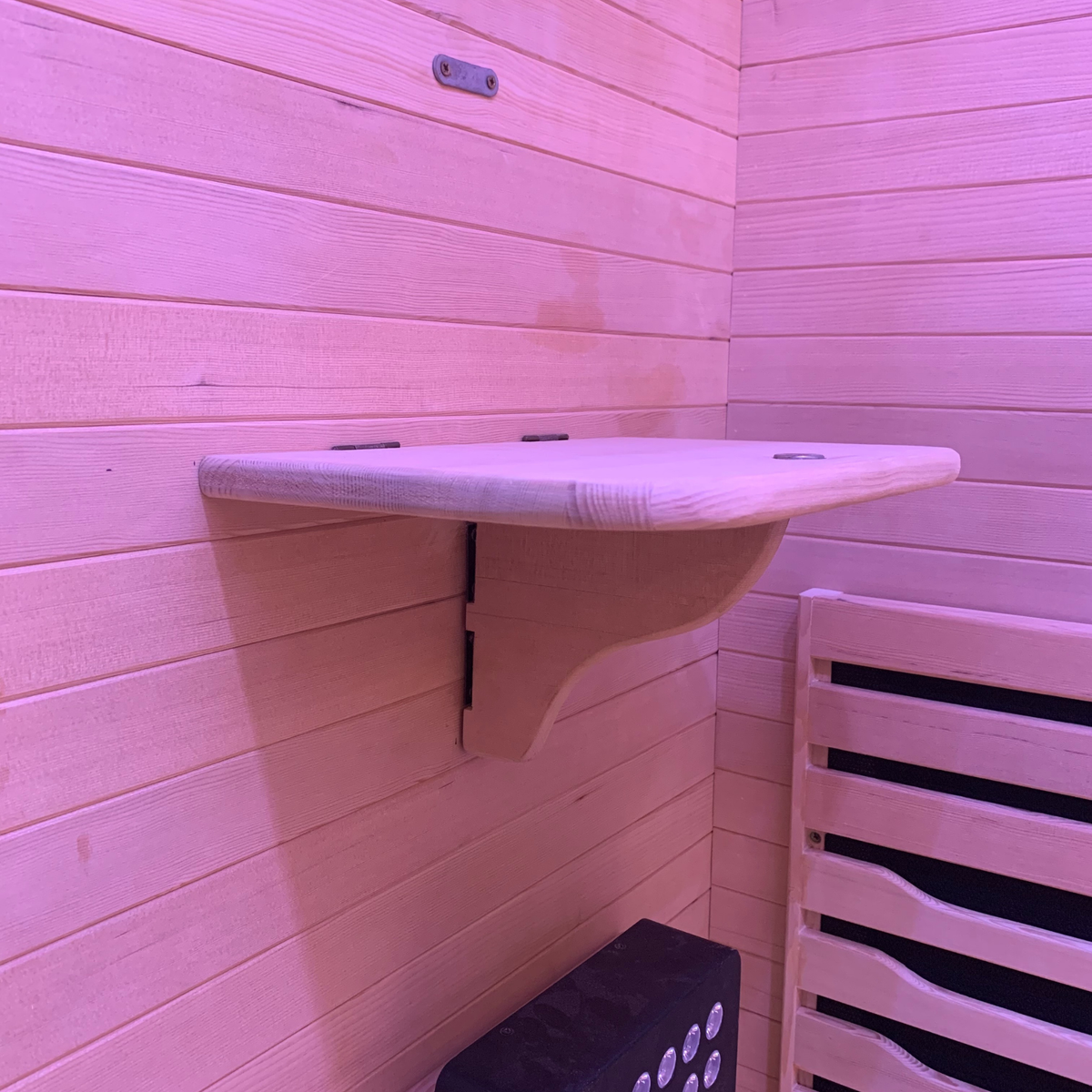 Wooden shelf inside a Full Spectrum Indoor Sauna with pink lighting for enhancing relaxation.