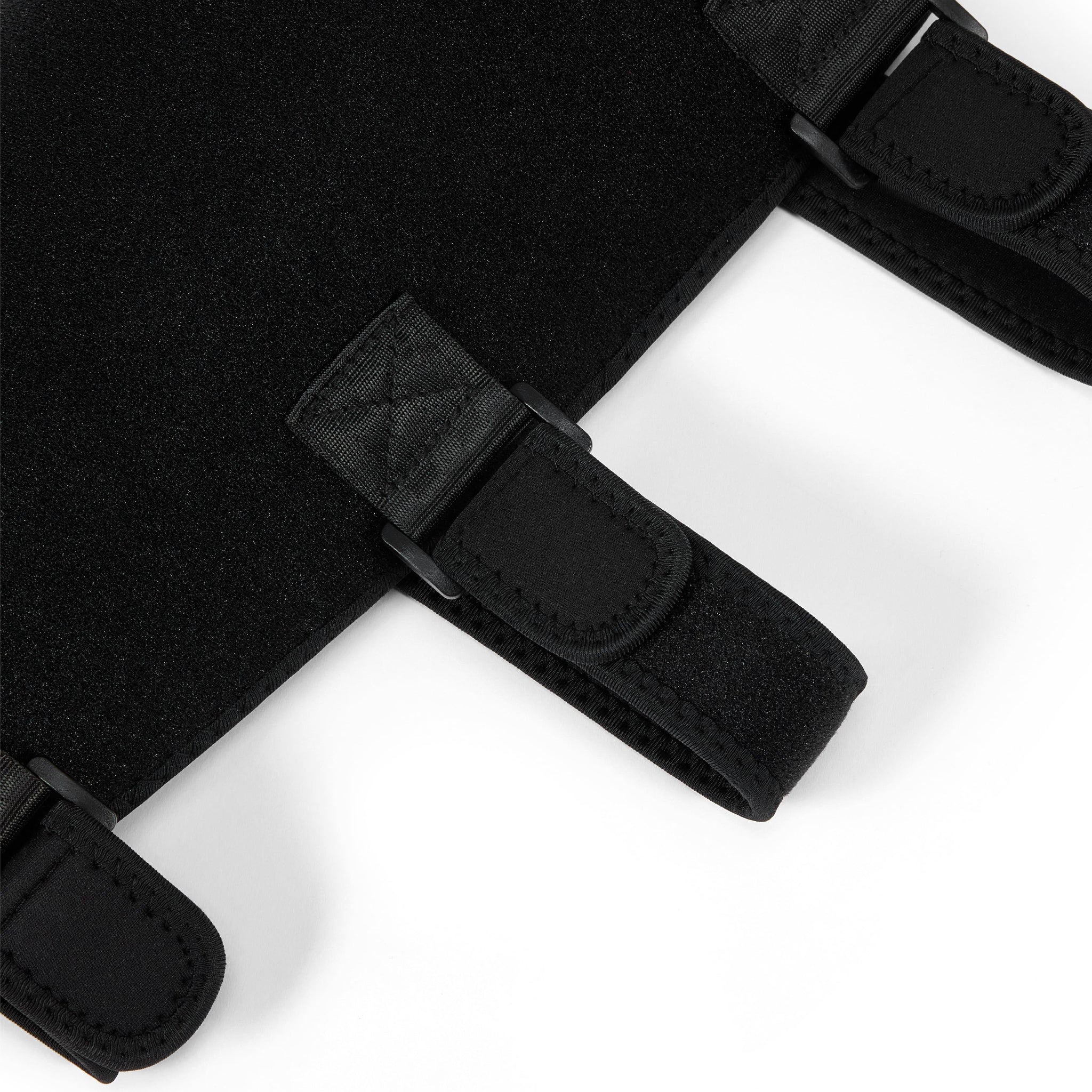 Close-up of black straps with buckles from Nicebeam leg wrap on a white background