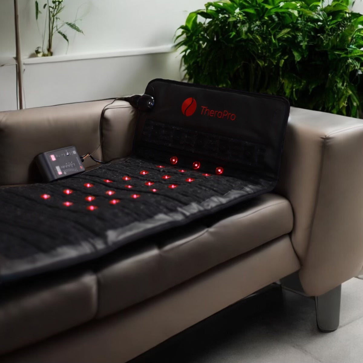 TheraPro red light therapy pad resting on a couch, showcasing multiple red lights for effective therapy.