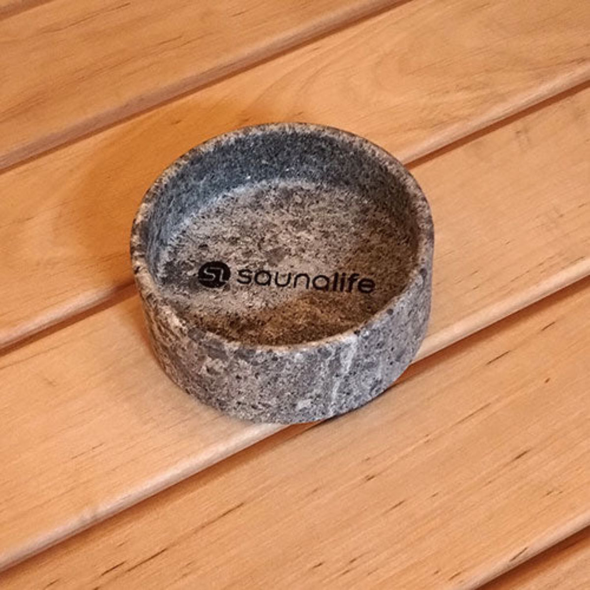 Stone bowl with 'saunalife' branding on a wooden surface