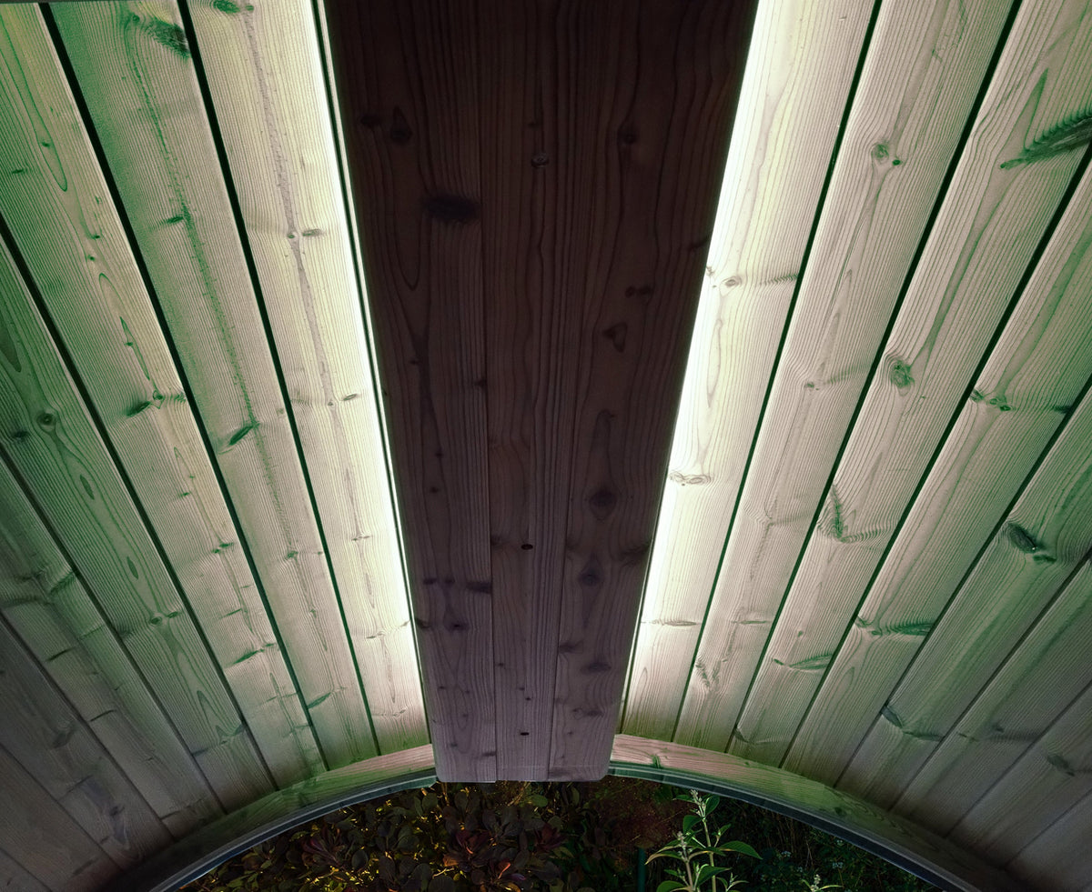 Wooden sauna leaning with green lightd on ceiling