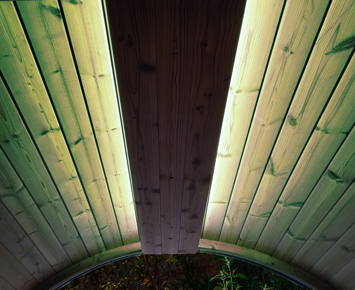 Wooden sauna with green lights on a wooden ceiling