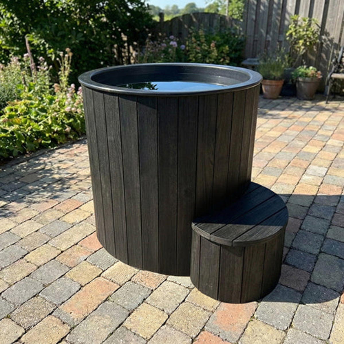 SaunaLife S1B cold and hot immersion tub filled with water on a brick deck