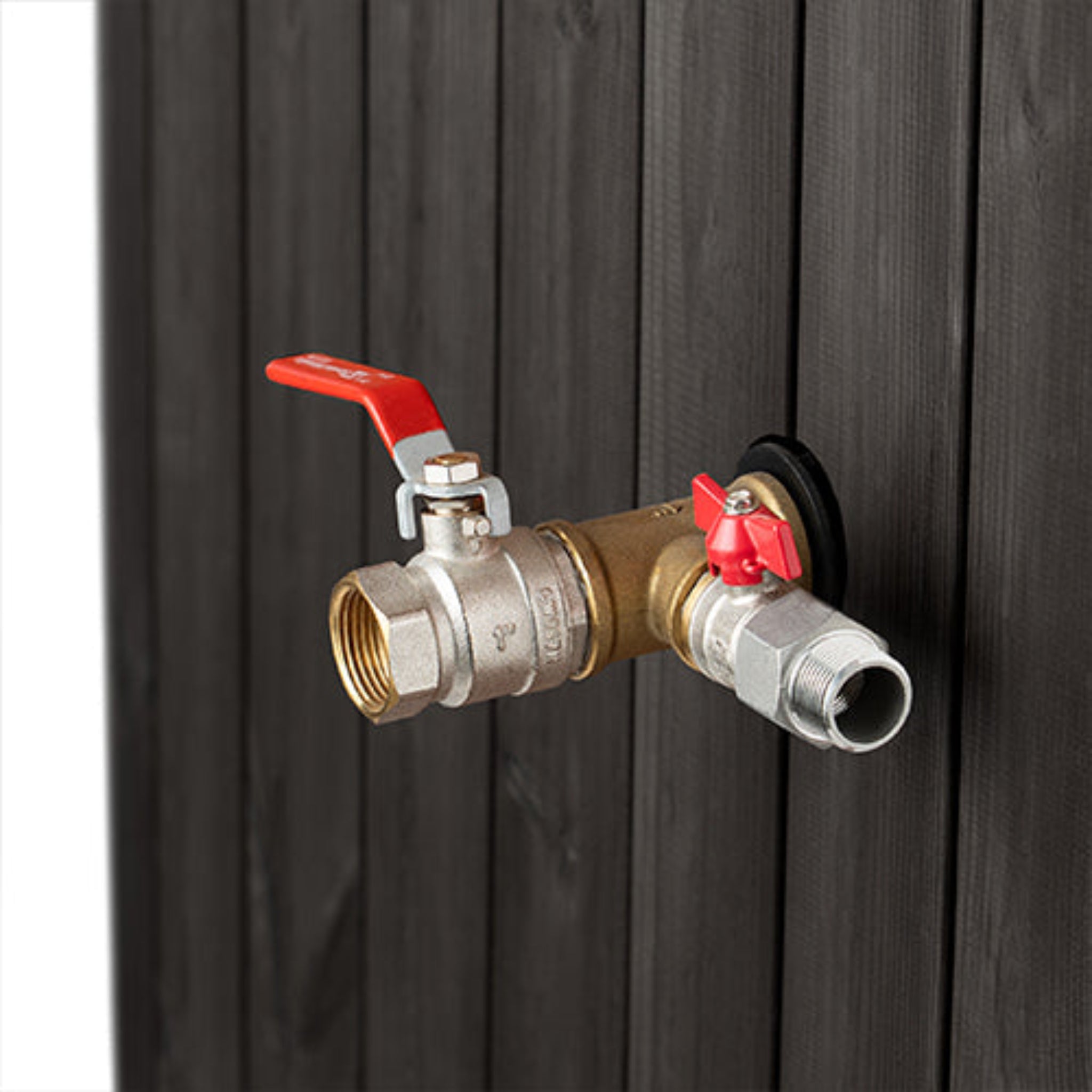 Brass outdoor faucet with red handles attached to a black Saunalife tub