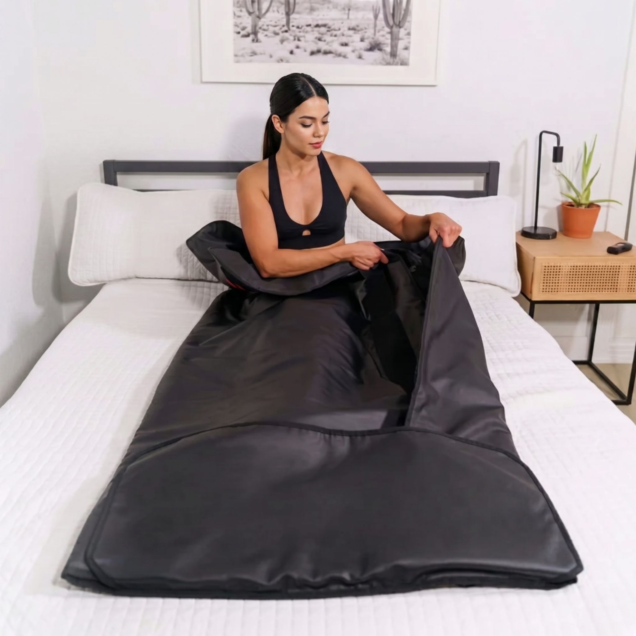 Woman sitting on a bed holding a black sauna bag