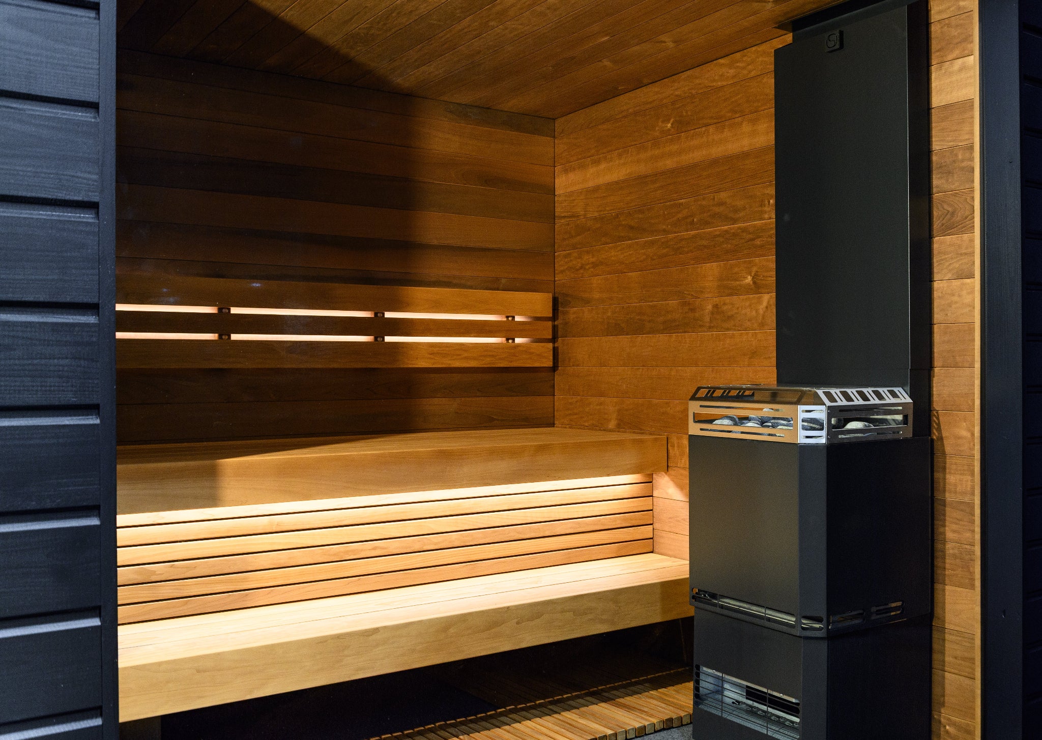 Saunum Air L sauna heater inside sauna with bench view