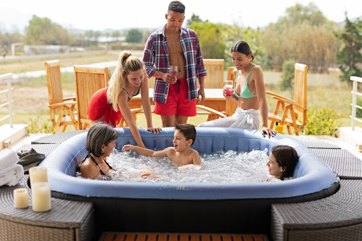 Family enjoying a hot tub outdoors with a scenic background