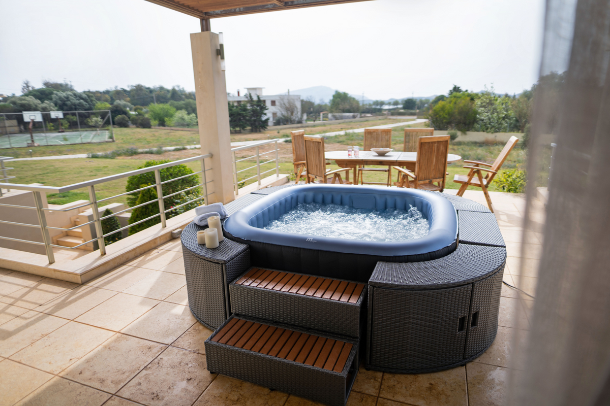 Hot tub on a patio with outdoor furniture and scenic view