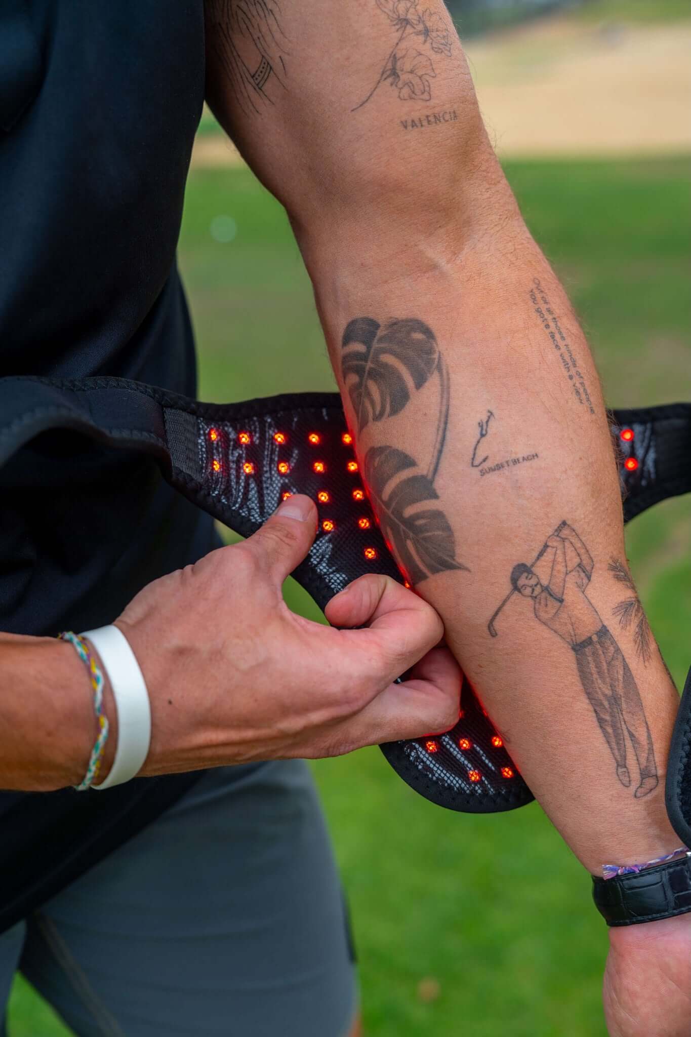 Person adjusting the wrap with orange lights on a grassy background
