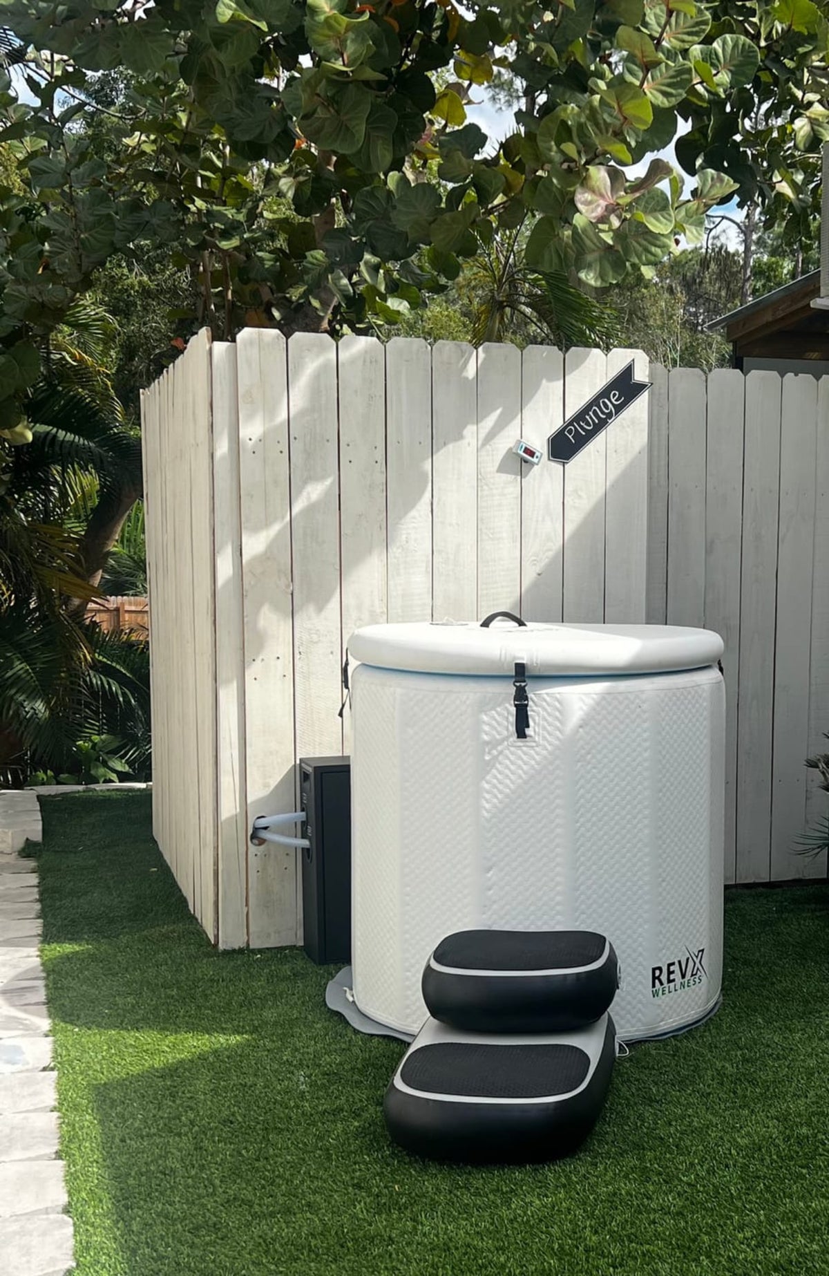 RevX Inflatable Barrel and steps beside a garden fence