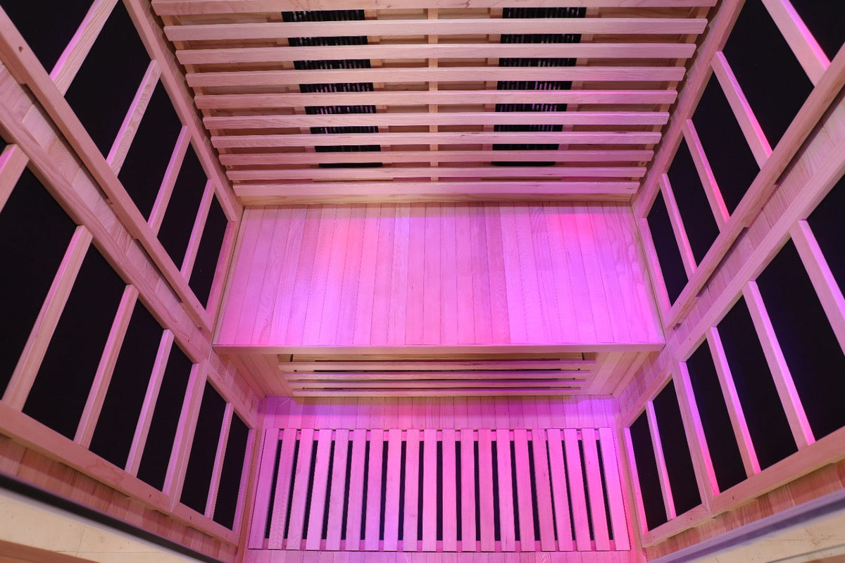 Interior view of a Blisspod Full Spectrum Infrared Sauna featuring low EMF and glowing pink lights.