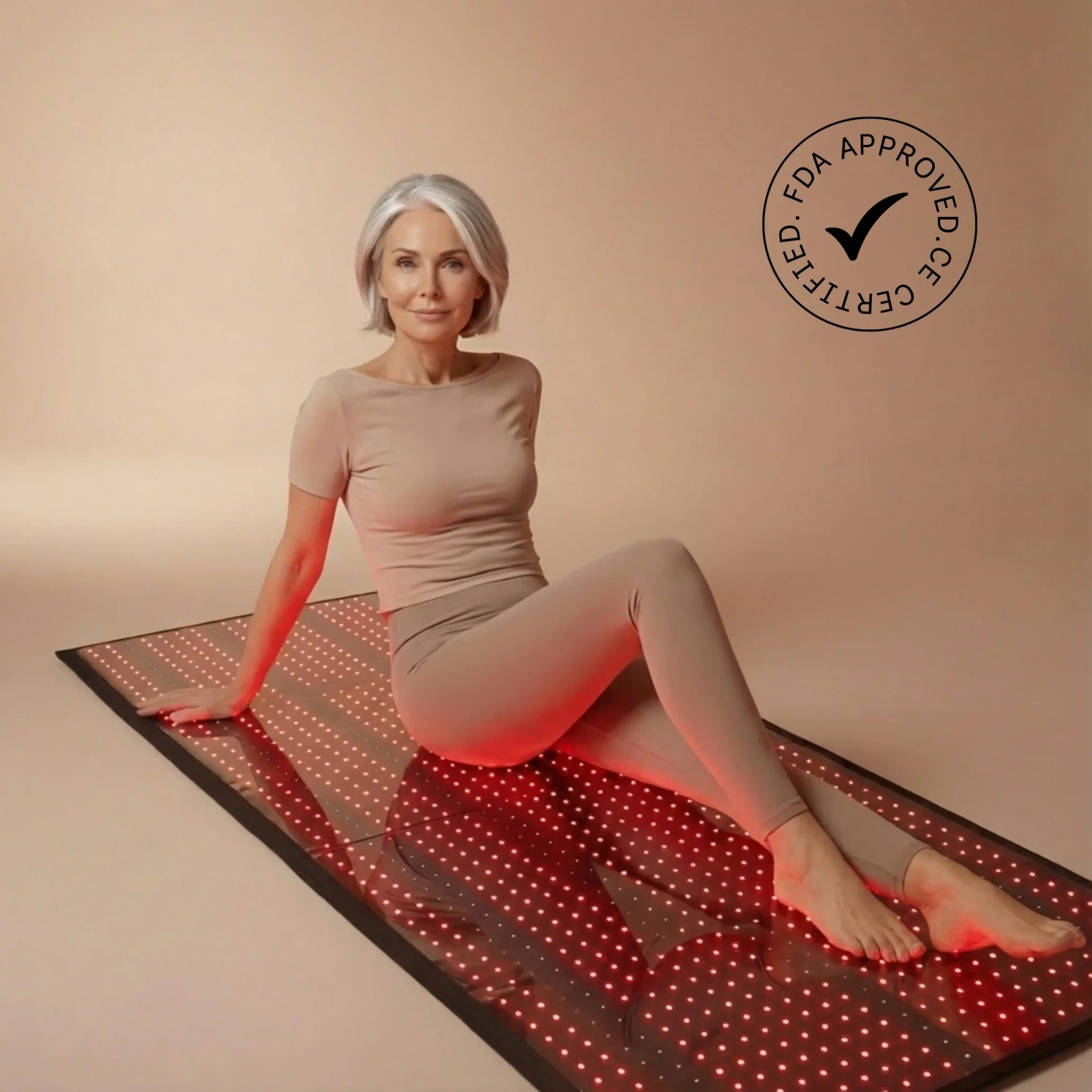 Woman sitting on a red light therapy mat with an FDA certified logo.