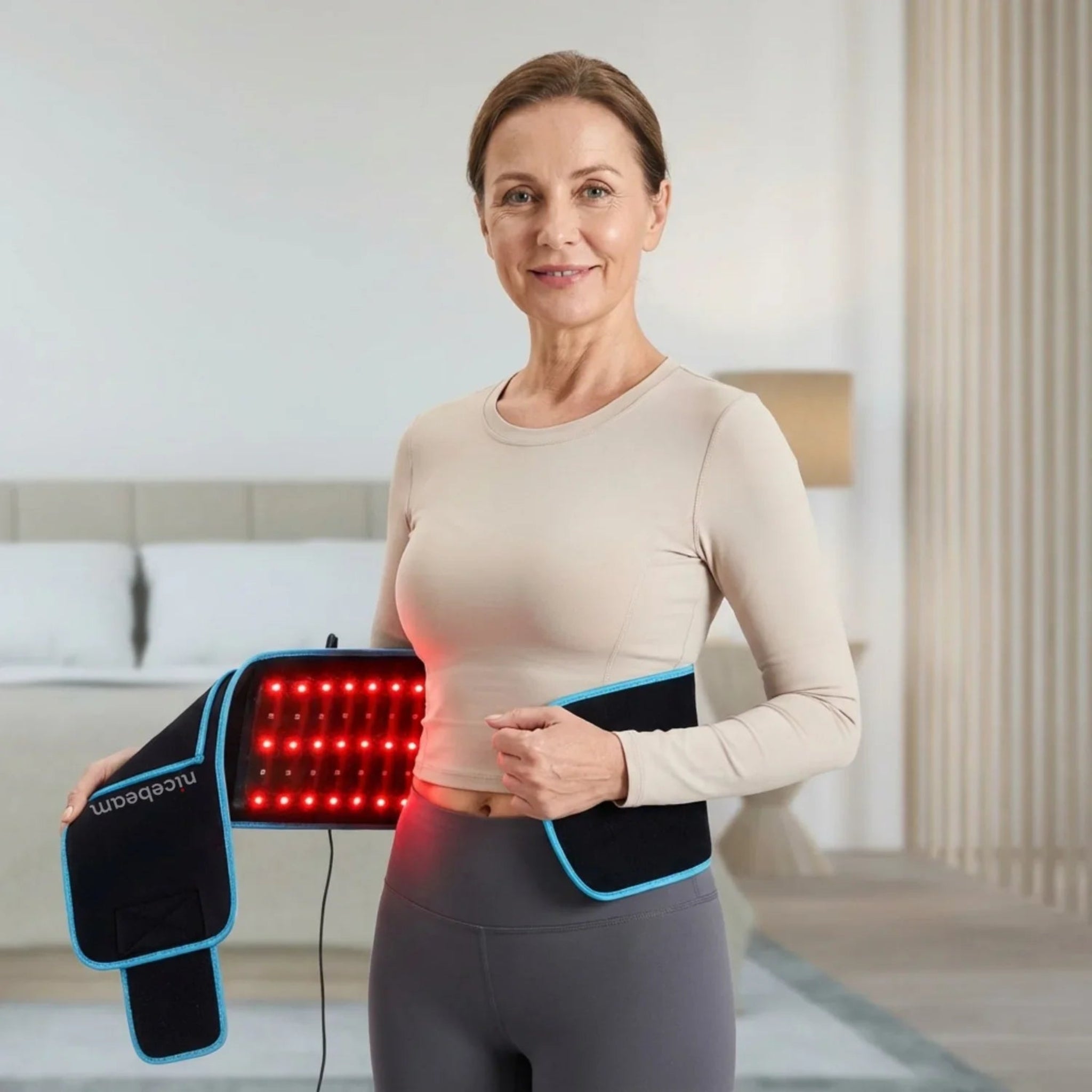 Woman using Nicebeam red light therapy device belt in a home setting
